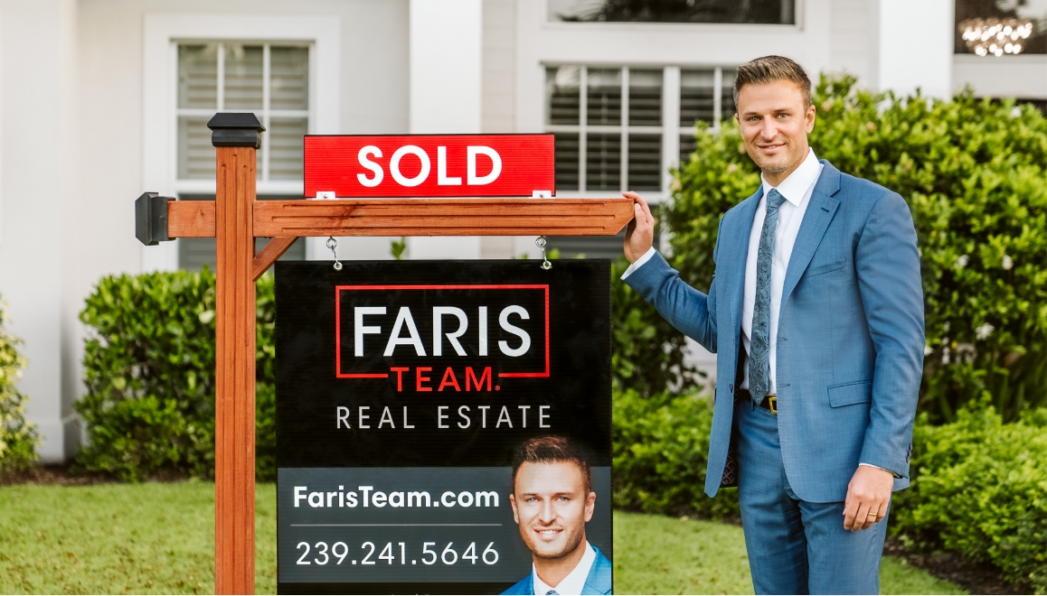 Mark Faris standing next to a Faris Team sign in front of a sold property